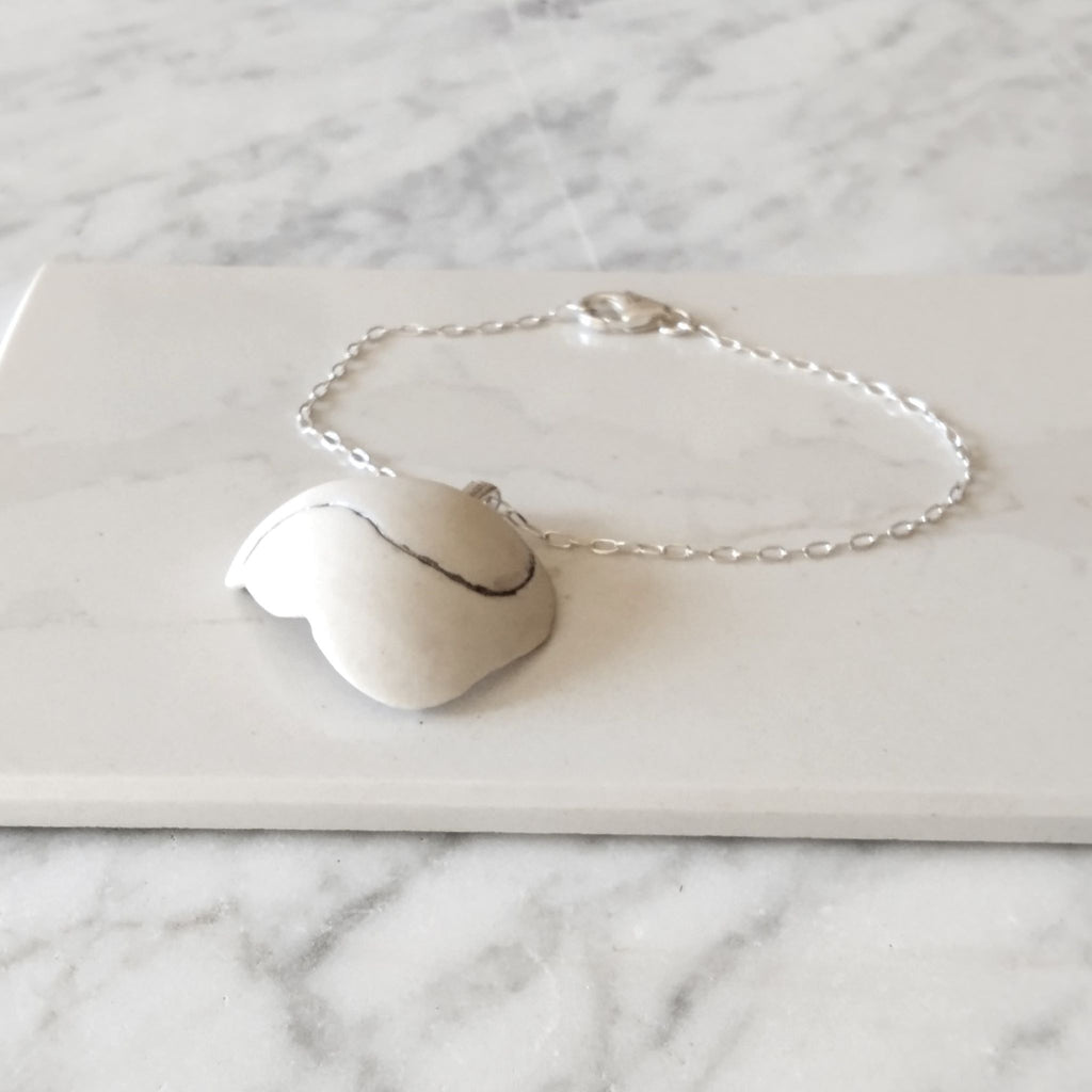 Dettaglio della nuvola in porcellana bianca con inclusioni in platino, bracciale Cumulo Collezione Aria