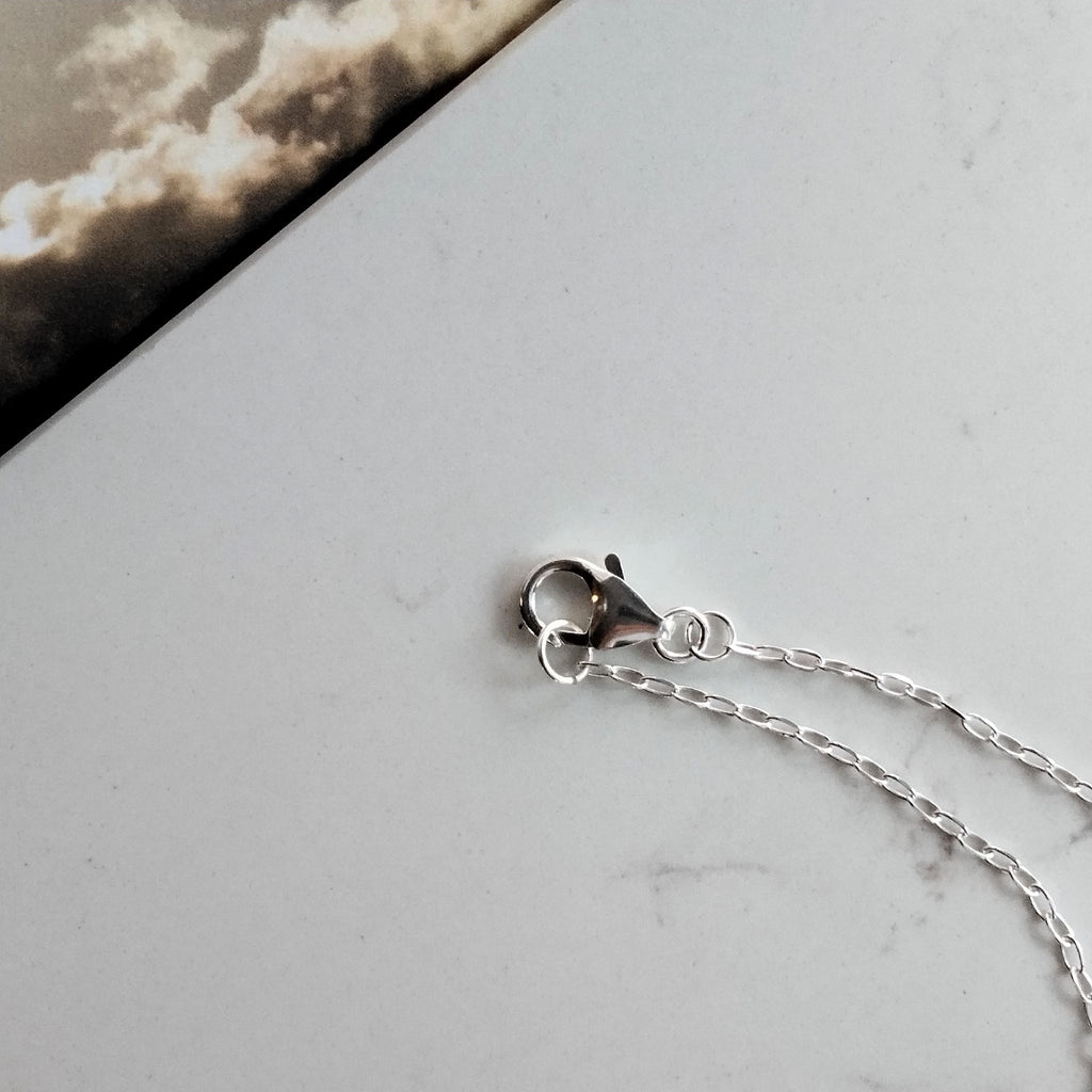 Dettaglio della chiusura a moschettone e delle maglie della catena in argento della collana Cumulo Maviart.