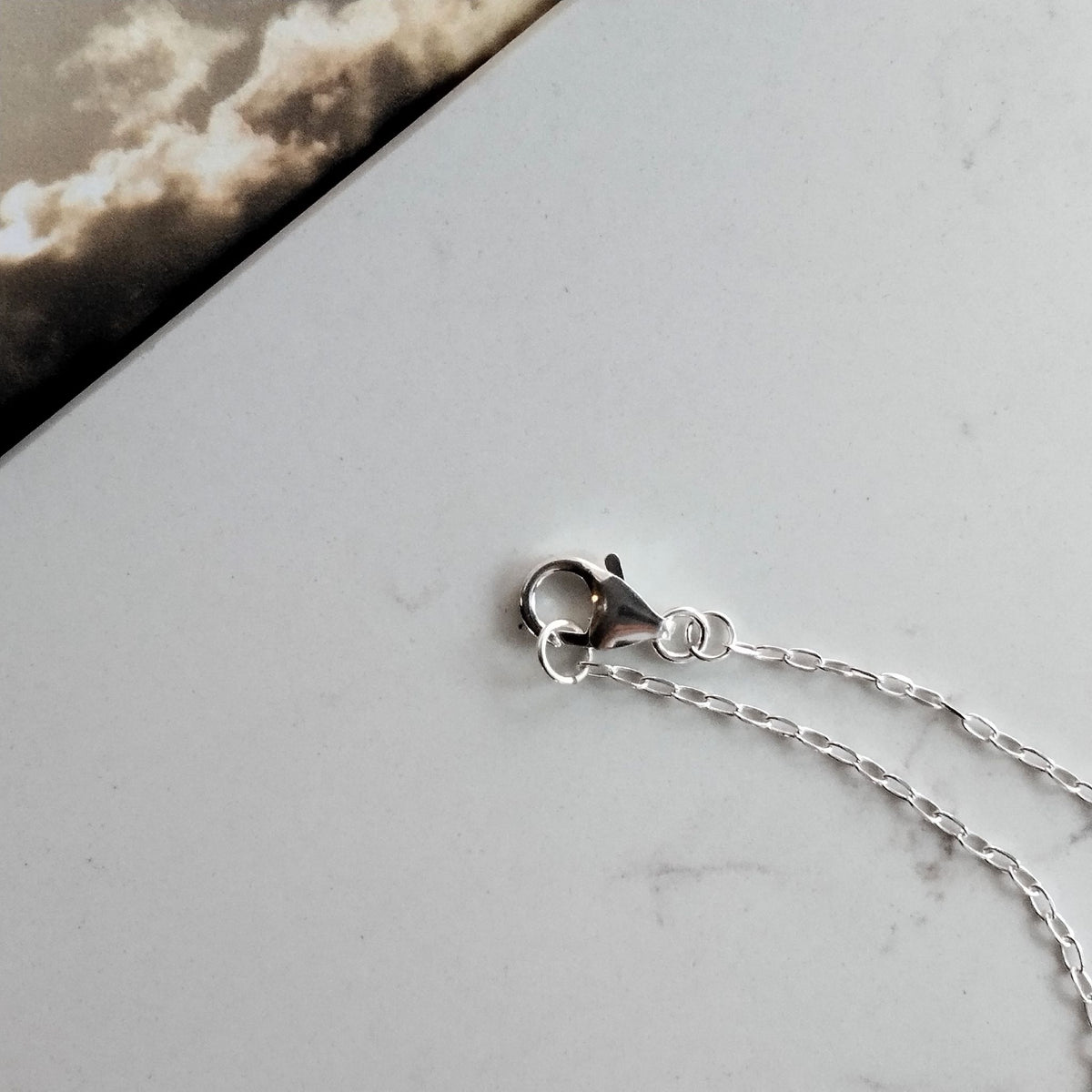 Dettaglio della chiusura a moschettone e delle maglie della catena in argento della collana Cumulo Maviart.