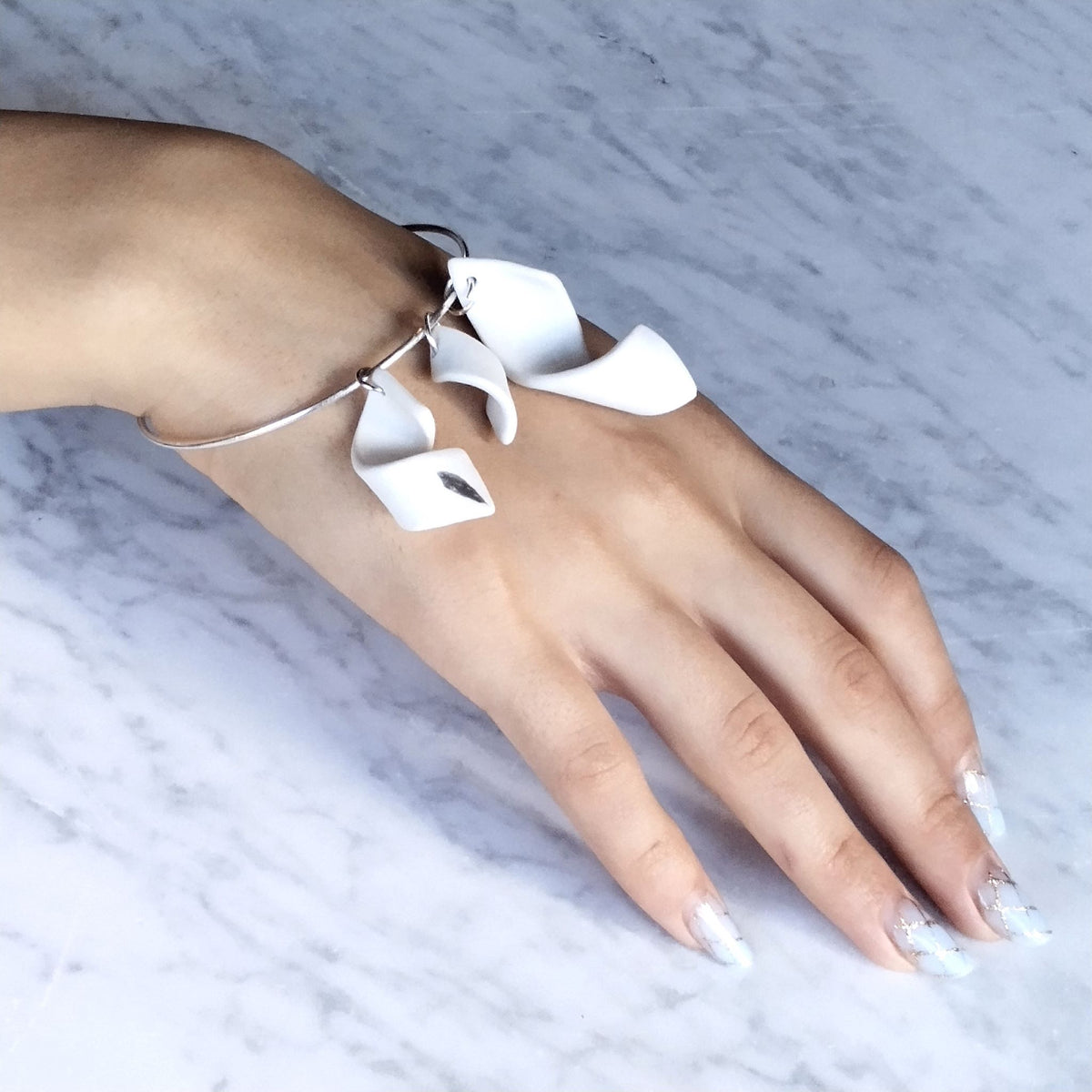 Bracciale Turbine Maviart indossato: tre turbini in porcellana di dimensioni crescenti su bangle in argento