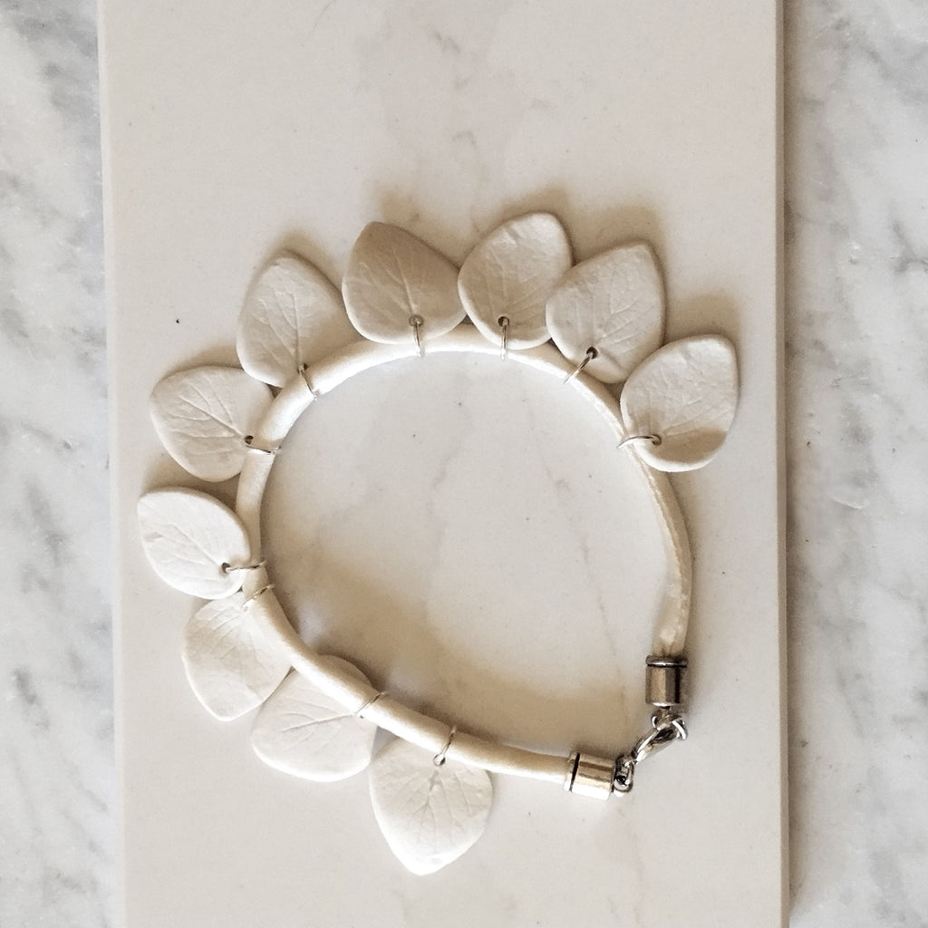 Dettaglio delle foglie in porcellana bianca opaca con inserti in argento, bracciale Collezione Aria