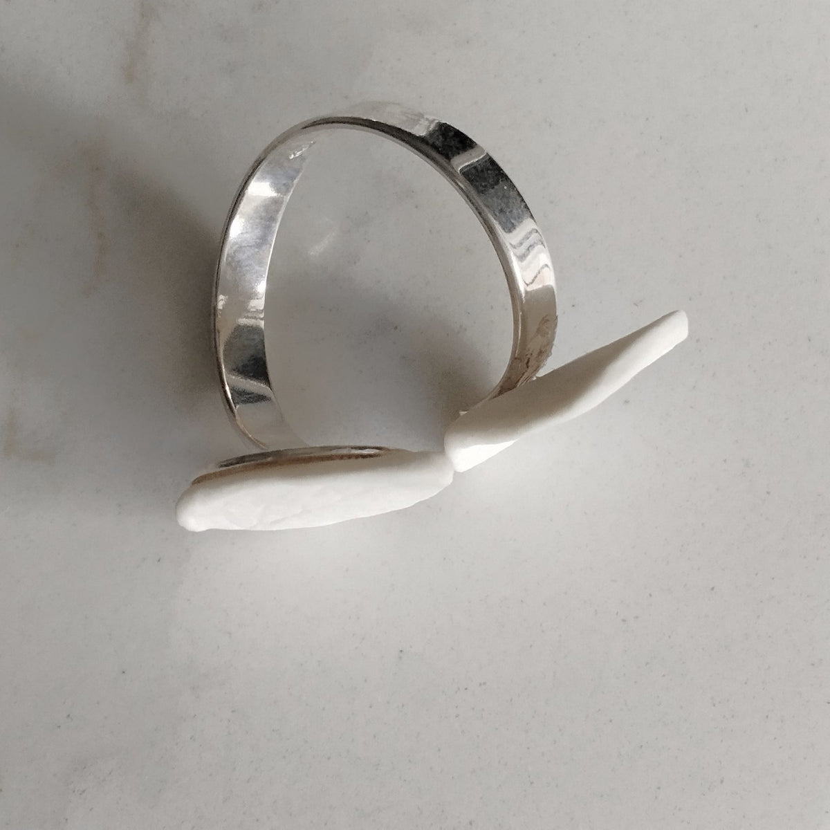 Anello Foglie in porcellana bianca e argento, linea Soffio. Dettaglio base argento.