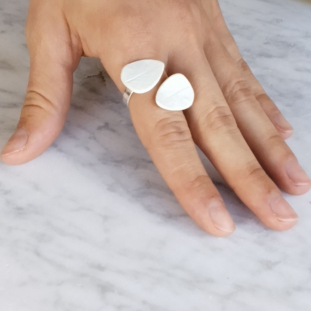 Anello Foglie in porcellana bianca e argento, linea Soffio, posa dall'alto indossato.
