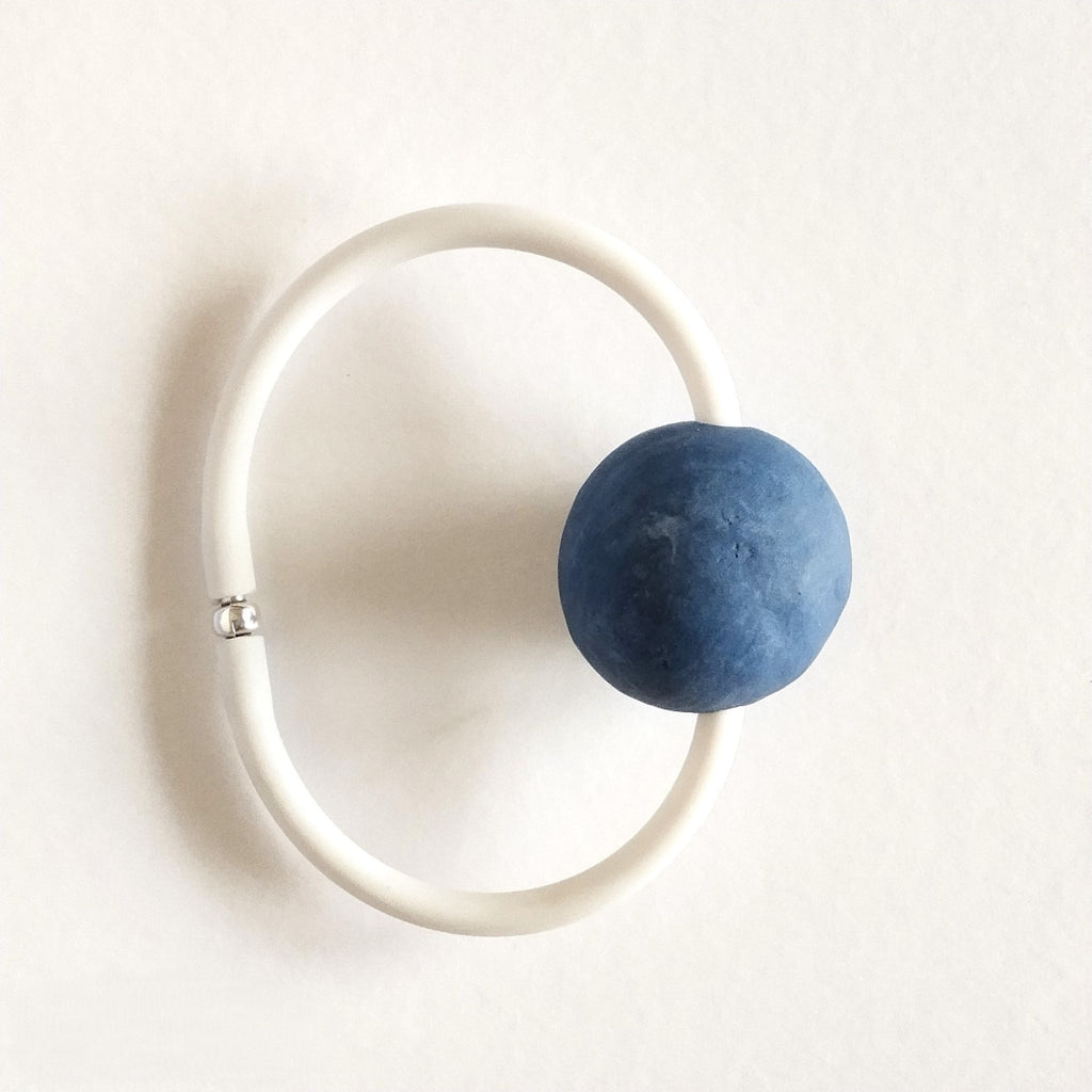 Bracciale AB-01 con sfera in porcellana nerikomi colori del mare, posa dall'alto su cartoncino. Maviart 