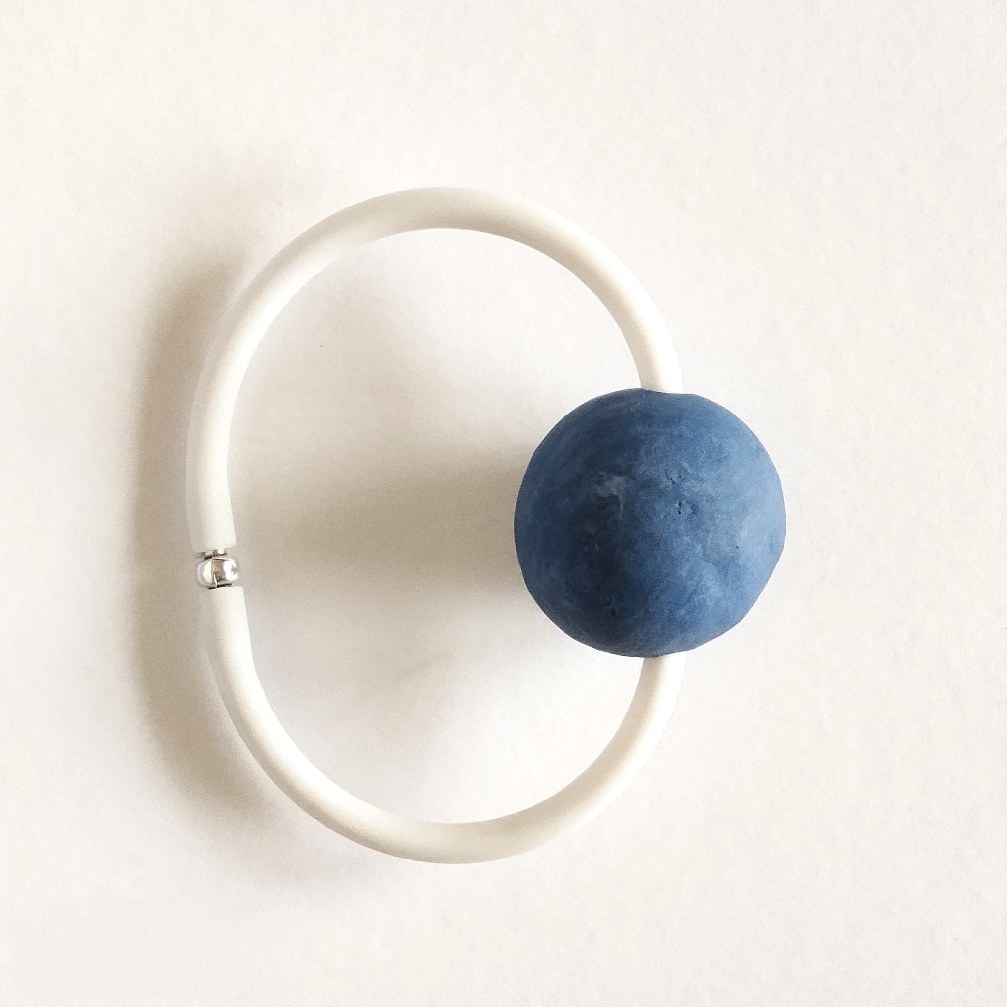 Bracciale AB-01 con sfera in porcellana nerikomi colori del mare, posa dall'alto su cartoncino. Maviart 