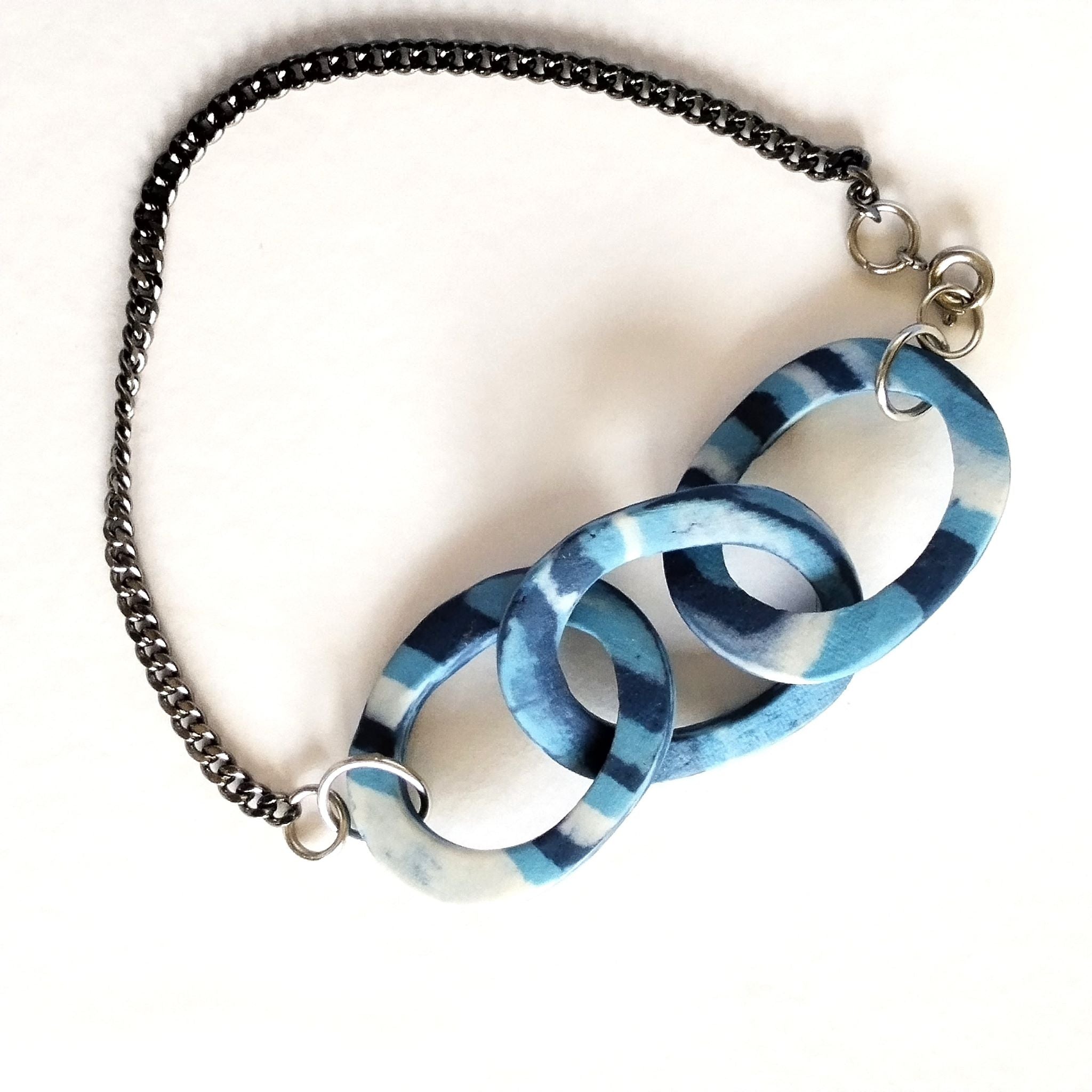 Bracciale AB-03 a maglie ovali in porcellana nerikomi colori del mare, posa dall'alto su cartoncino bianco – Maviart