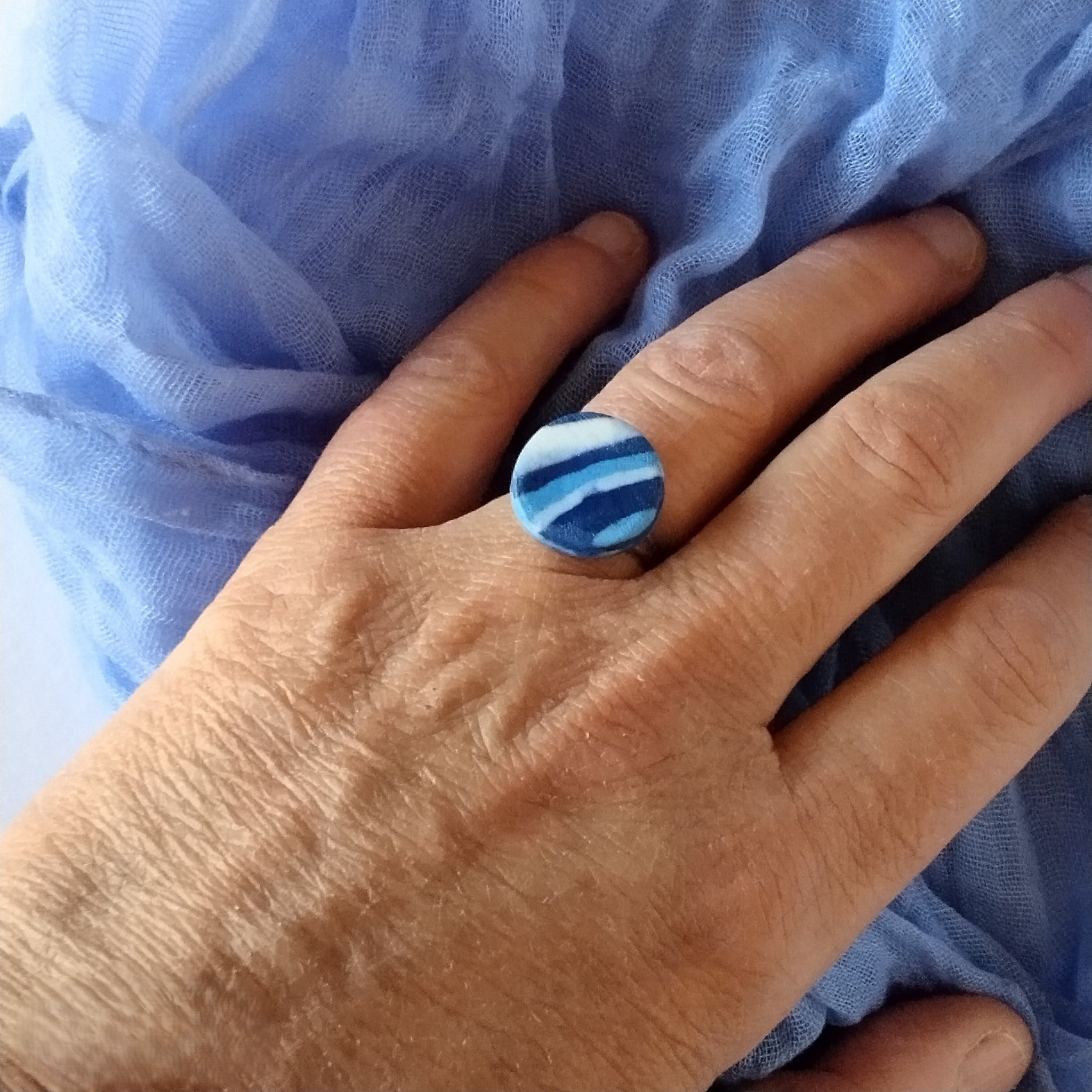 Anello rotondo, porcellana nerikomi, colori del mare, indossato