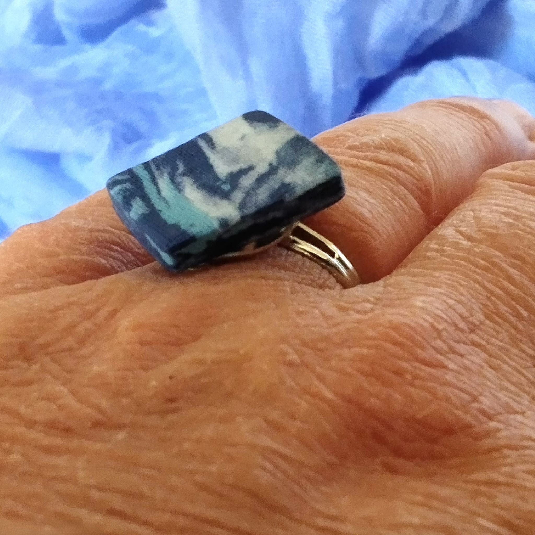 anello romboidale in  porcellana nerikomi, colori del mare, bversione indossata.