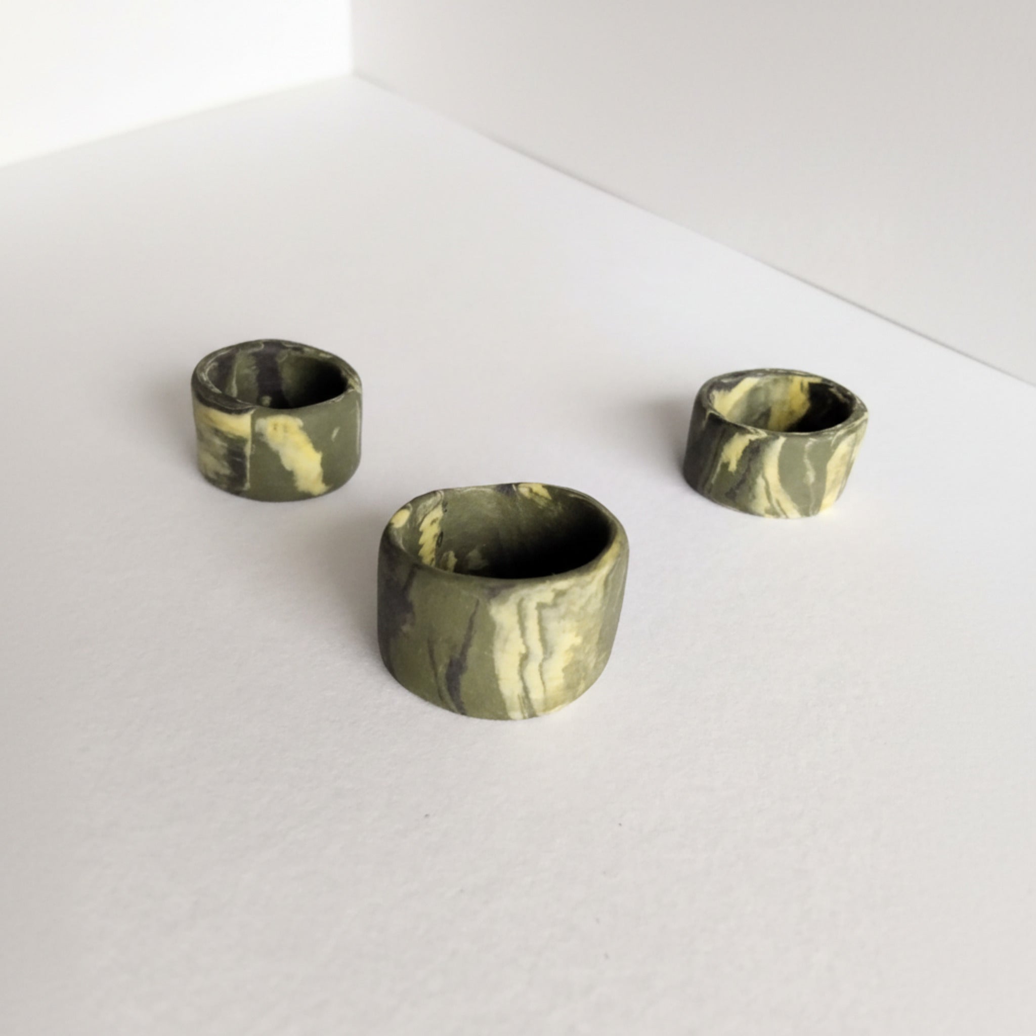 Anello a fascia in porcellana nerikomi colori della terra, posa dall'alto su sfondo bianco – varianti 1,2,3 - Maviart