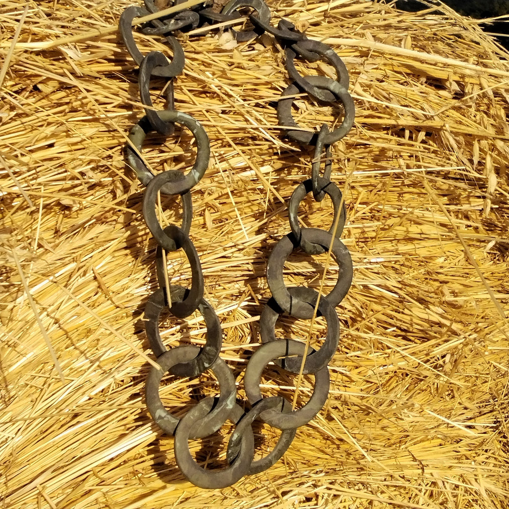 Collana a maglie circolari in porcellana nerikomi fatta a mano, posa su sfondo di paglia naturale - Maviart