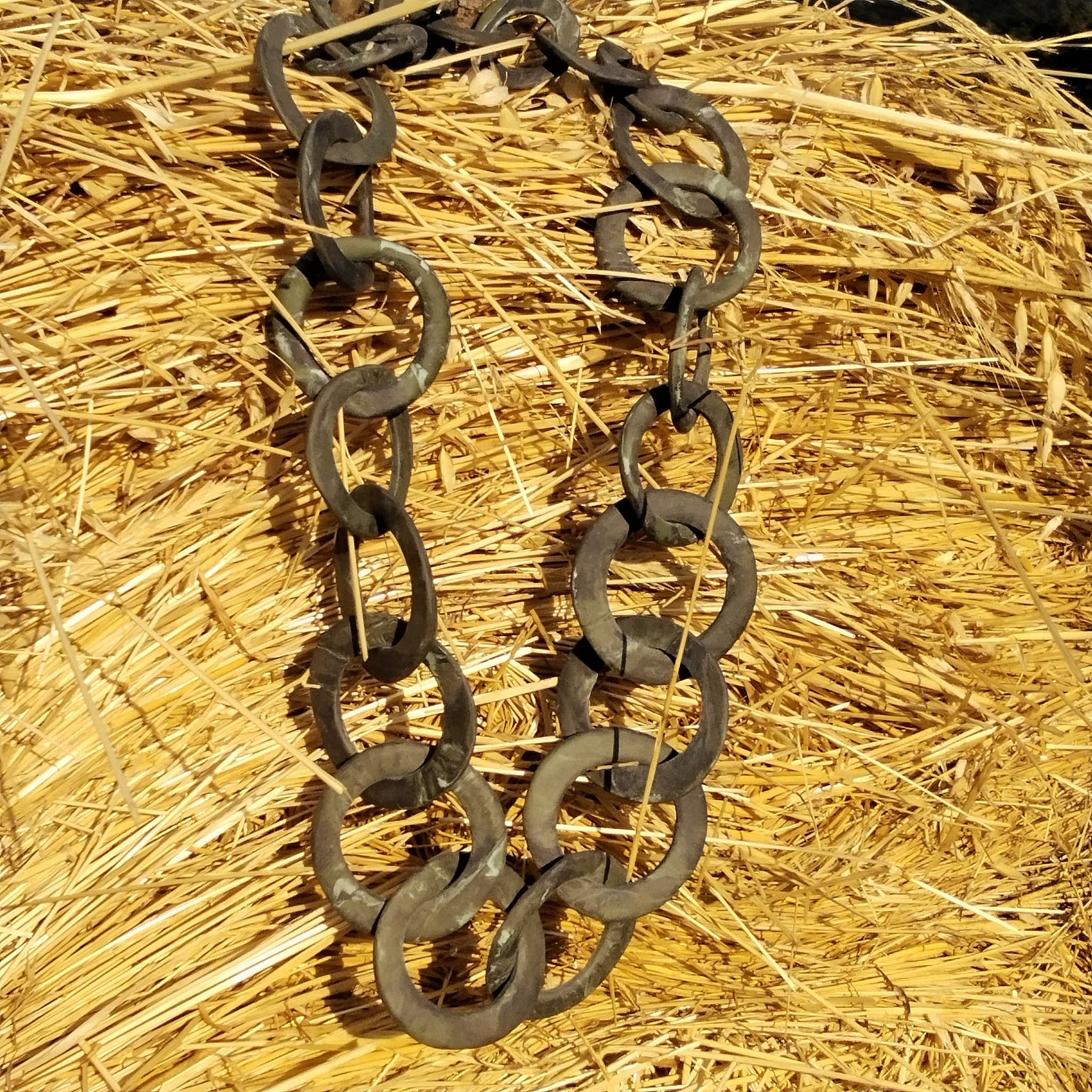 Collana a maglie circolari in porcellana nerikomi fatta a mano, posa su sfondo di paglia naturale - Maviart