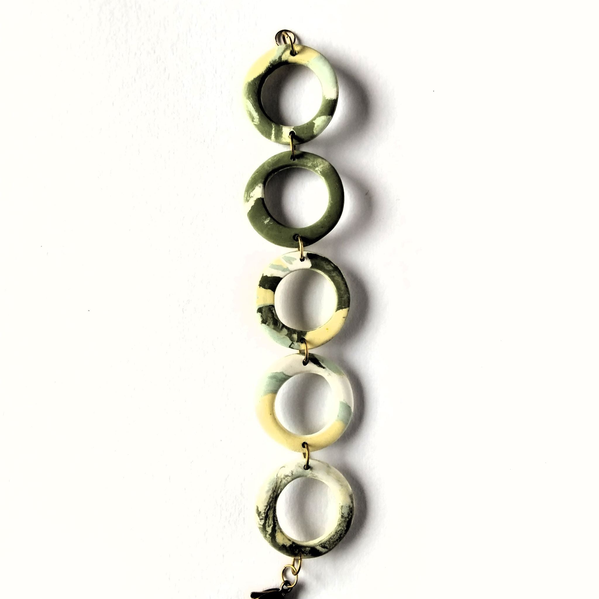 Bracciale cerchi in porcellana nerikomi colori della terra – posa dall'alto su sfondo bianco, luce naturale  Maviart 