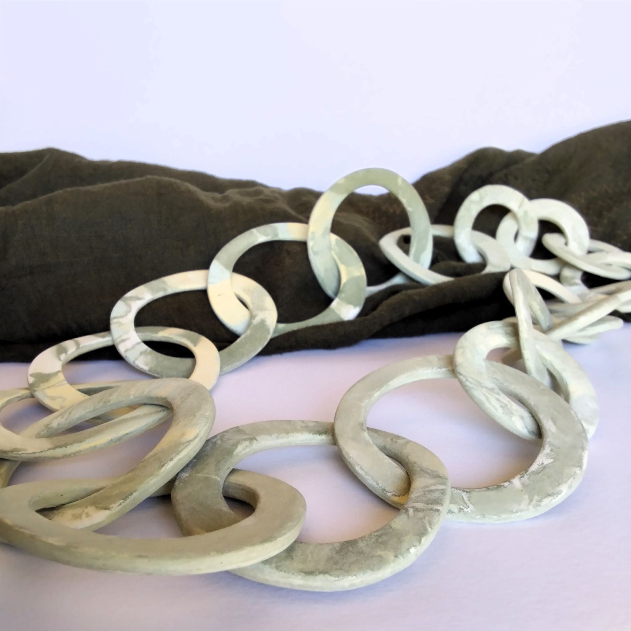Collana a maglie circolari in porcellana nerikomi colori della terra — vista laterale su sfondo bianco Maviart